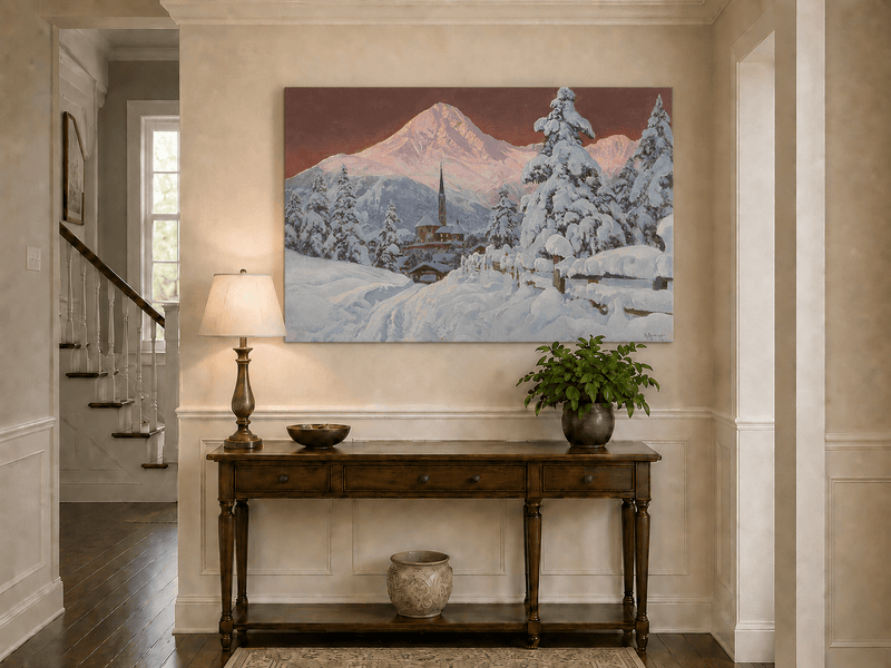 Unframed hand-painted snowy alpine village oil painting with a church and pink mountain peaks displayed above an entryway console table.