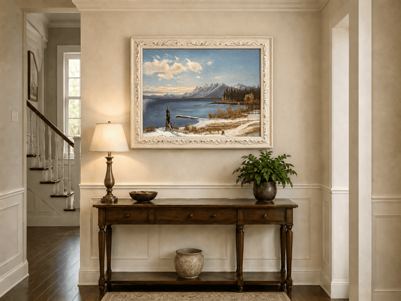 Framed hand-painted snowy lake oil painting with a winter path and distant mountain view displayed above an entryway console table.