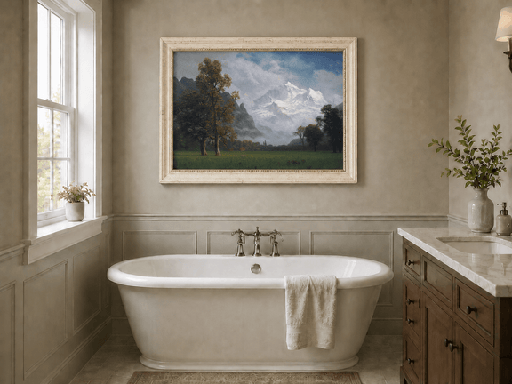 Framed hand-painted snowy mountain valley oil painting with a meadow and tall trees displayed above a freestanding bathtub.