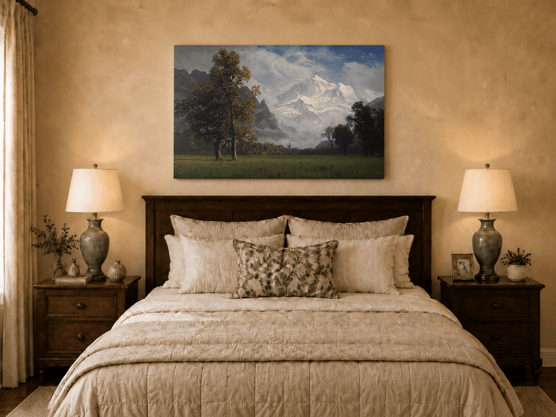 Unframed hand-painted snowy mountain valley oil painting with a meadow and tall trees displayed above a wooden bed in a neutral bedroom.
