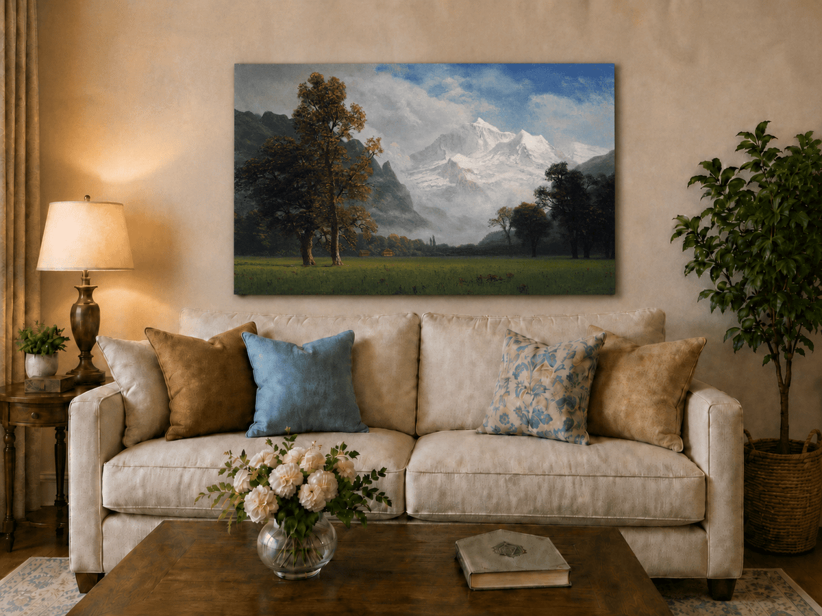 Unframed hand-painted snowy mountain valley oil painting with a meadow and tall trees displayed above a neutral living room sofa.