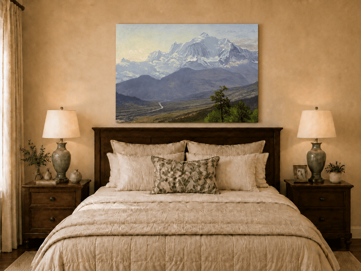 Unframed hand-painted snowy mountain valley oil painting with a winding river and rolling hills displayed above a wooden bed in a neutral bedroom.