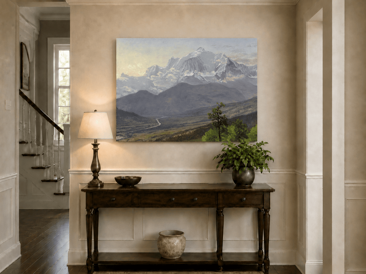 Unframed hand-painted snowy mountain valley oil painting with a winding river and rolling hills displayed above an entryway console table.