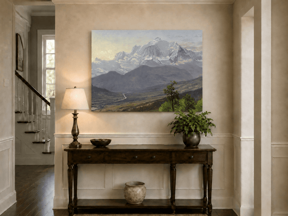 Unframed hand-painted snowy mountain valley oil painting with a winding river and rolling hills displayed above an entryway console table.