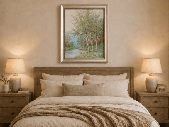 Framed hand-painted spring river oil painting with a fisherman beneath leafy trees displayed above a wooden bed in a neutral bedroom.