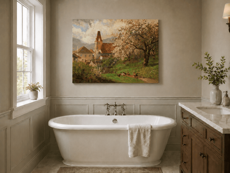 Unframed hand-painted spring village oil painting with a church and flowering tree displayed above a freestanding bathtub.