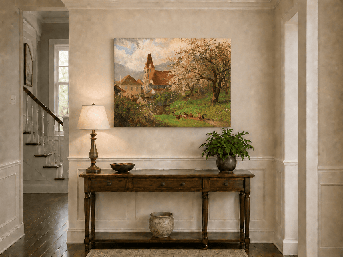 Unframed hand-painted spring village oil painting with a church and flowering tree displayed above an entryway console table.