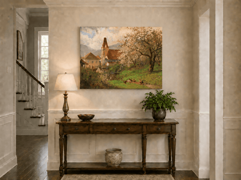 Unframed hand-painted spring village oil painting with a church and flowering tree displayed above an entryway console table.