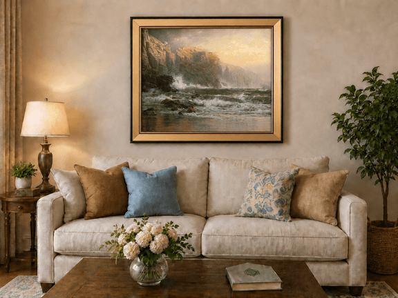 Framed hand-painted stormy seascape oil painting with a reef, surf and golden coastal cliffs displayed above a neutral living room sofa.