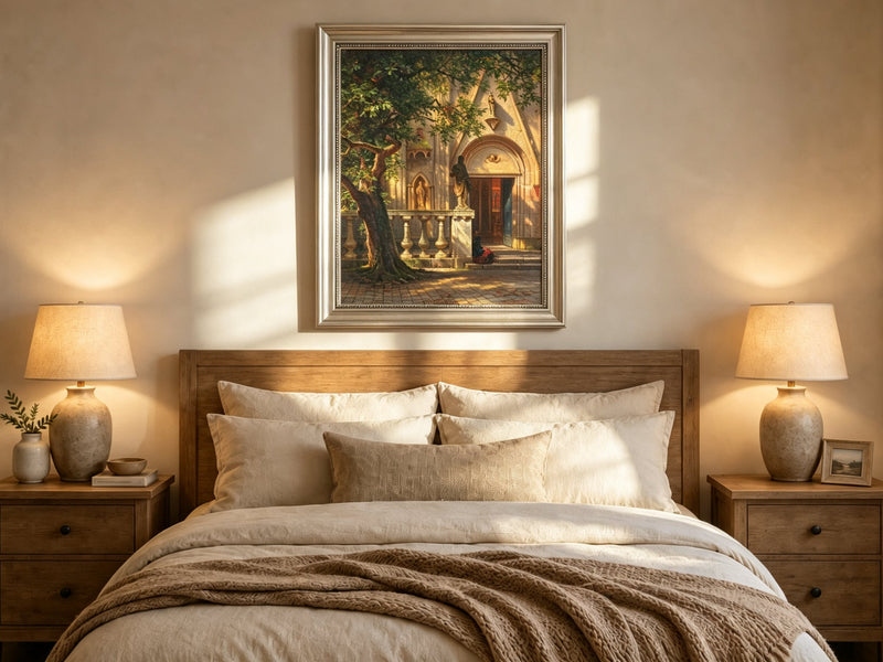 Framed hand-painted church courtyard oil painting with an old tree in warm sunlight displayed above a wooden bed in a neutral bedroom.