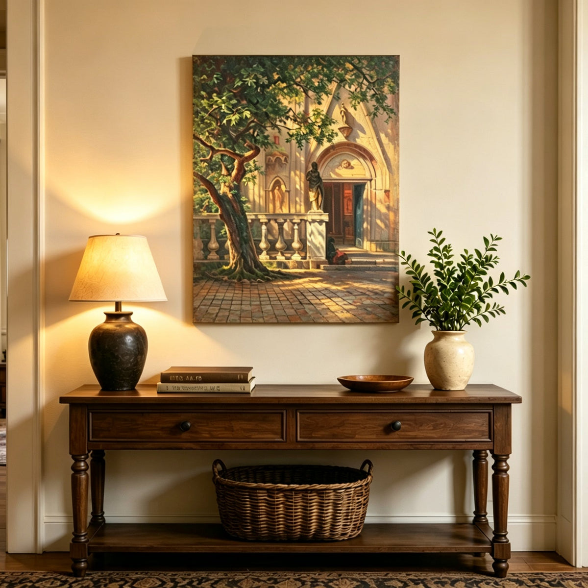 Unframed hand-painted church courtyard oil painting with an old tree in warm sunlight displayed above an entryway console table.