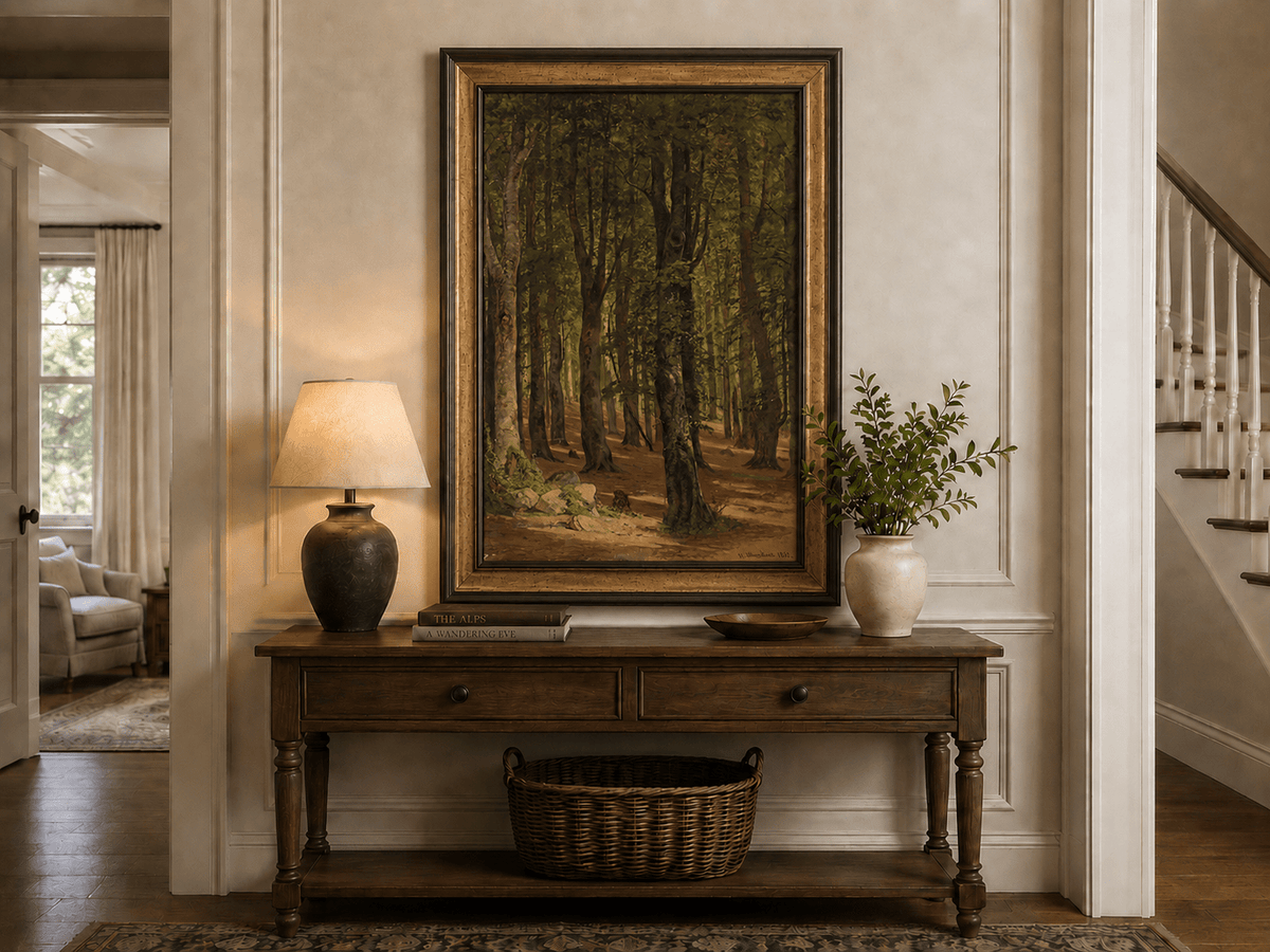 Framed hand-painted sunlit forest interior oil painting with a warm path beneath tall trees displayed above an entryway console table.