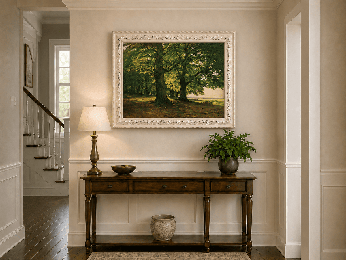 Framed hand-painted sunlit forest oil painting with two large spreading trees displayed above an entryway console table.