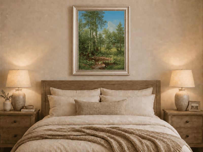 Framed hand-painted sunlit forest oil painting with a stream and wildflower glade displayed above a wooden bed in a neutral bedroom.