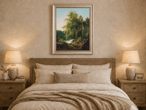 Framed hand-painted sunlit lakeside oil painting with rocks and leafy birch trees displayed above a wooden bed in a neutral bedroom.