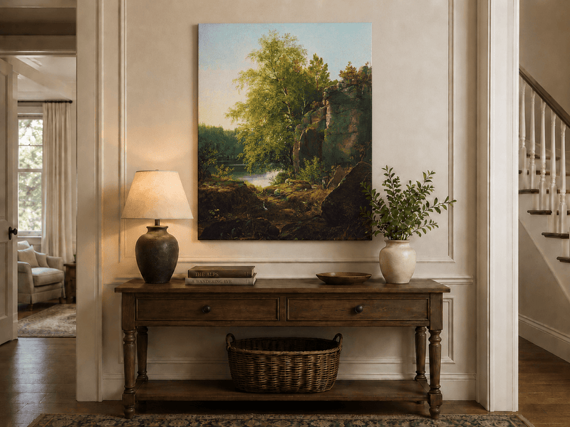 Unframed hand-painted sunlit lakeside oil painting with rocks and leafy birch trees displayed above an entryway console table.