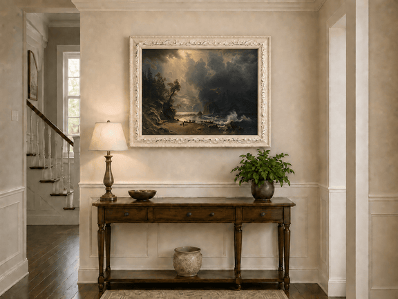 Framed hand-painted sunlit mountain valley oil painting beneath dramatic storm clouds displayed above an entryway console table.
