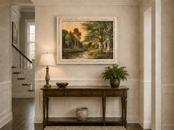 Framed hand-painted riverside grove oil painting with sunlit trees reflected at sunset displayed above an entryway console table.