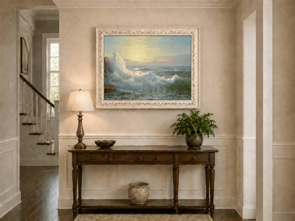 Framed hand-painted sunset seascape oil painting with luminous crashing waves displayed above an entryway console table.