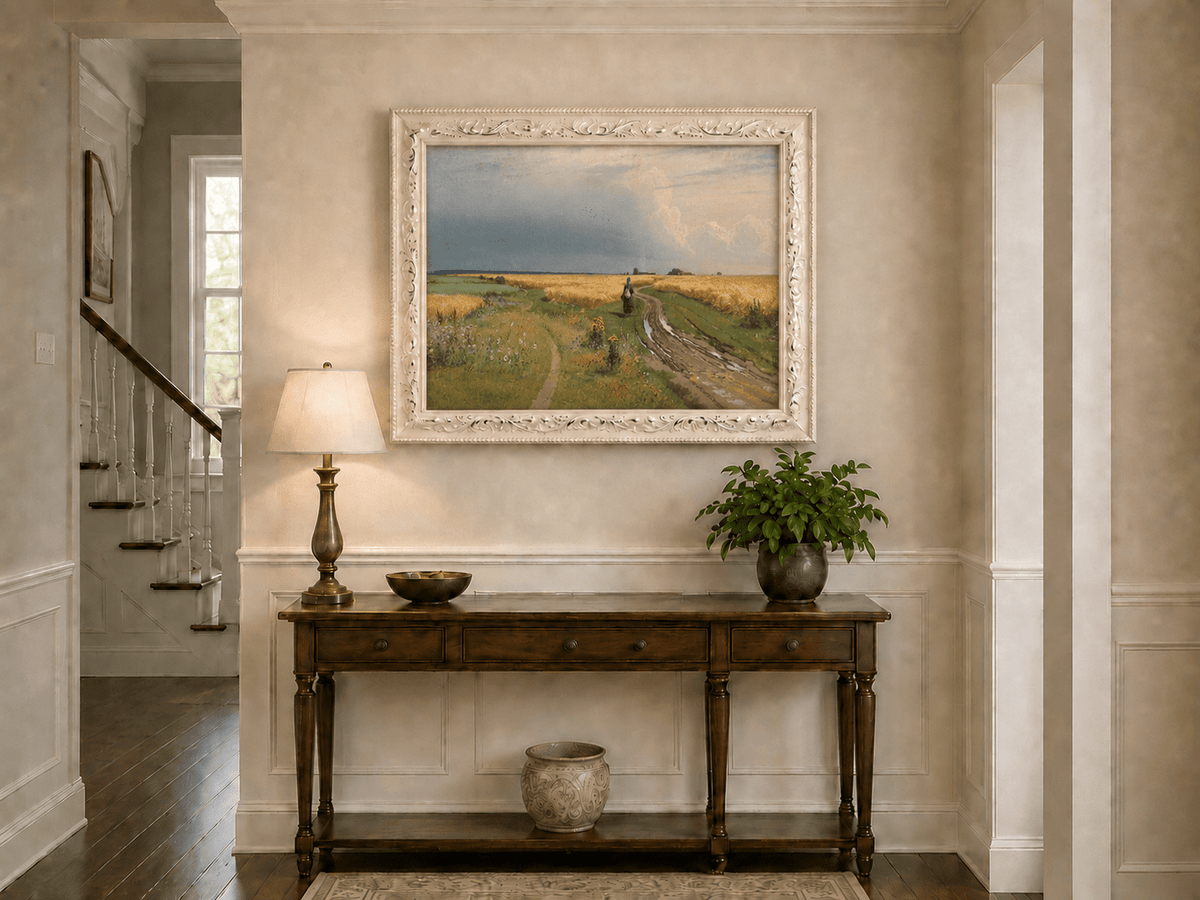 Framed hand-painted wheat field oil painting with a winding path beneath a dramatic sky displayed above an entryway console table.