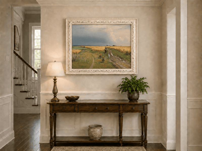 Framed hand-painted wheat field oil painting with a winding path beneath a dramatic sky displayed above an entryway console table.