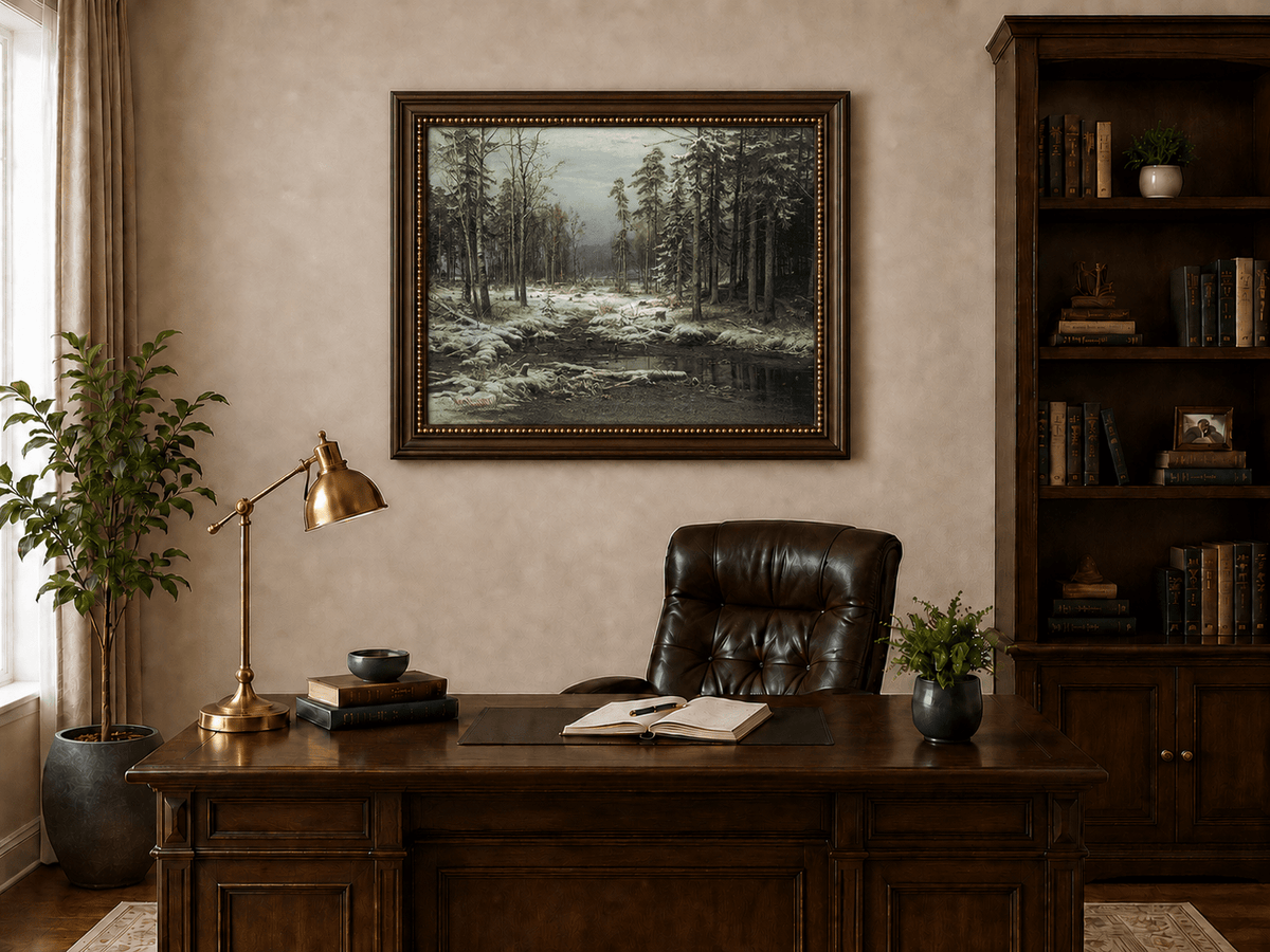 Framed hand-painted winter forest oil painting with a flowing stream through snowy woods displayed above a traditional home office desk.