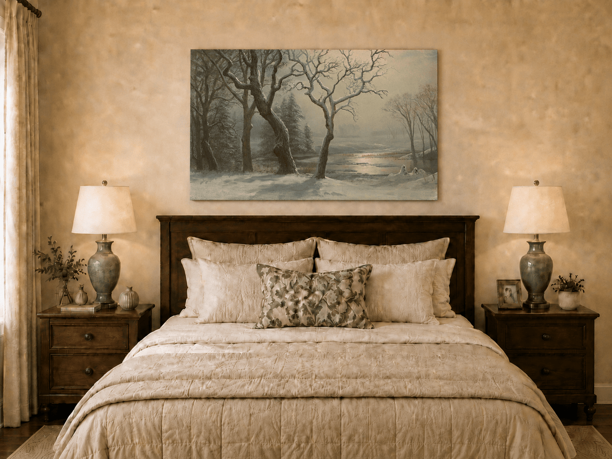 Unframed hand-painted winter river oil painting with bare trees in a snowy forest displayed above a wooden bed in a neutral bedroom.