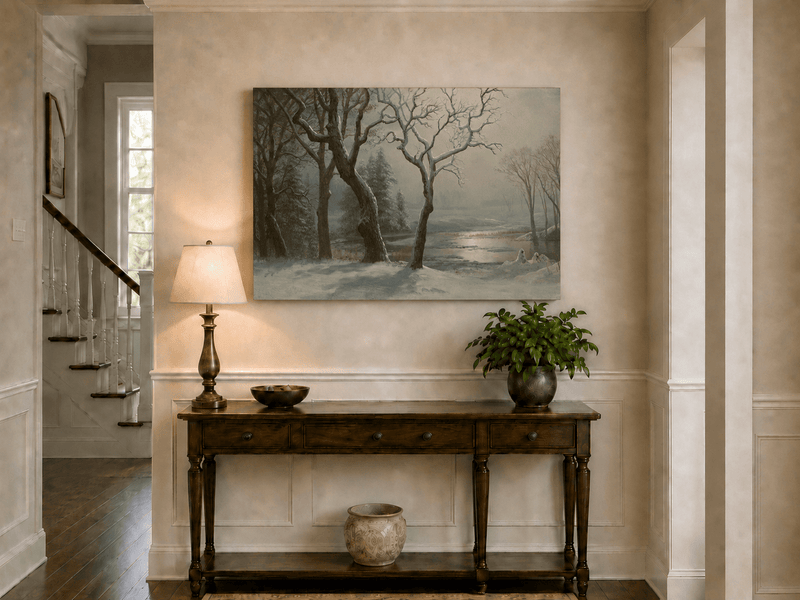 Unframed hand-painted winter river oil painting with bare trees in a snowy forest displayed above an entryway console table.