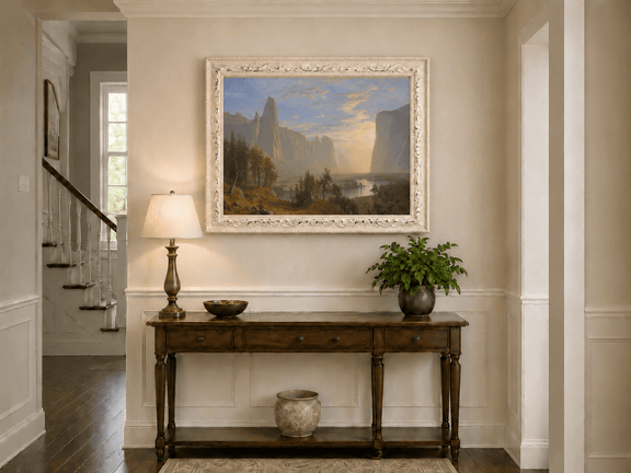 Framed hand-painted Yosemite Valley oil painting with towering cliffs in golden light displayed above an entryway console table.