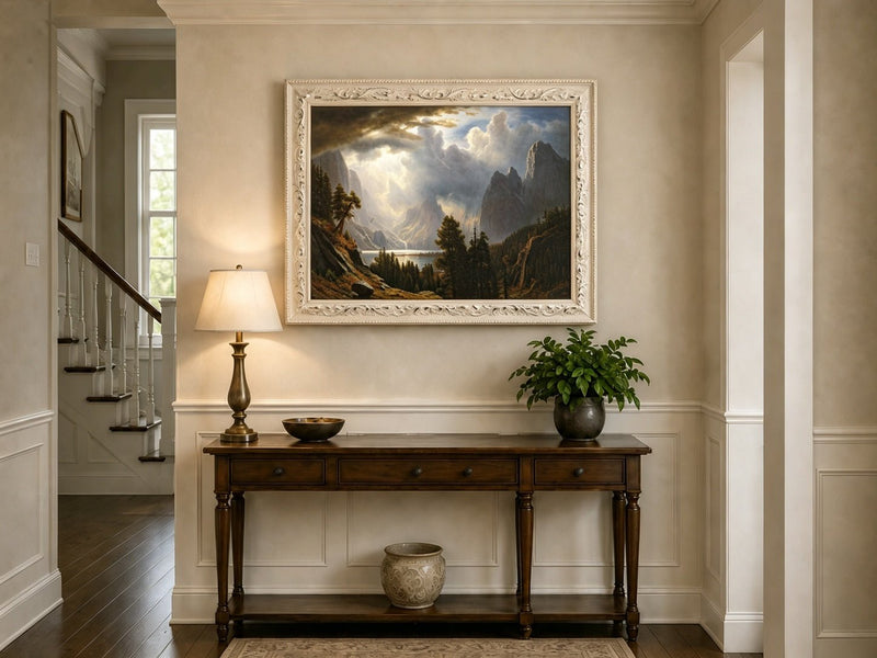 Framed hand-painted Yosemite Valley oil painting with storm clouds and dramatic sunbeams displayed above an entryway console table.