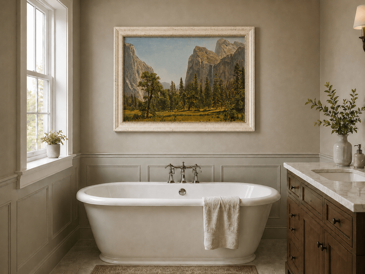 Framed hand-painted Yosemite Valley oil painting with a waterfall and towering granite cliffs displayed above a freestanding bathtub.